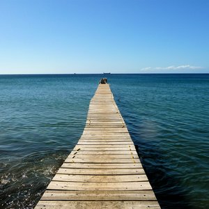 Wooden jetty over dark blue sea with infinity view on location in Dominica