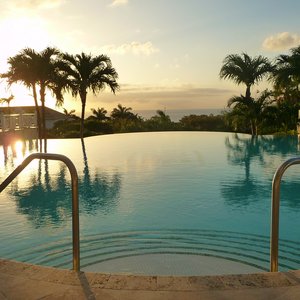 Infinity pool in tropical resort facing Caribbean sunset