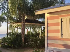 Gazebo And Pretty Pink Chattel House On A Barbados Sunset Beach With Palm Trees
