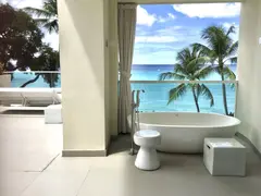 bathtub in open air environment with view to palm trees and sea