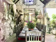boho decor of dining room in old mansion surrounded by beauttiful coloured flower garden
