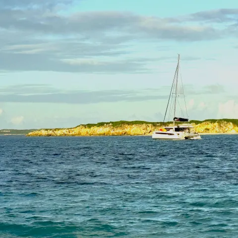 Catamaran in front of deserted island off the coast of St. Martin