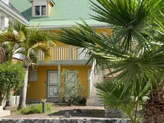 French Style Two Floor Yellow House With Outside Stairs And Porch