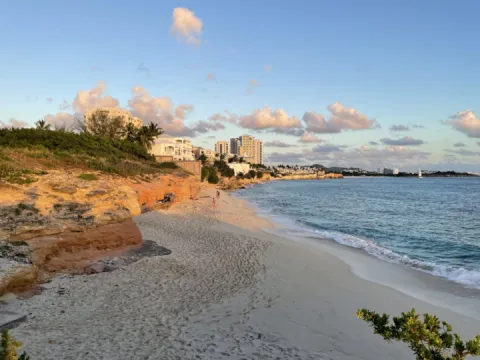 Golden Glow High Rocks In Sunset With Steps Down To A White Sandy Beach