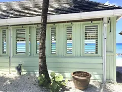 Light Green Wooden Veranda Front With Open Shatters To Look Through Towards The Sea